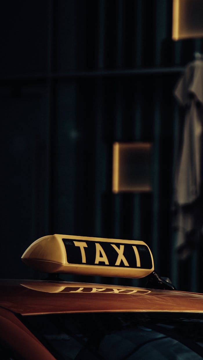 Close-up of a taxi under dim lights in Dubai, highlighting the urban atmosphere.